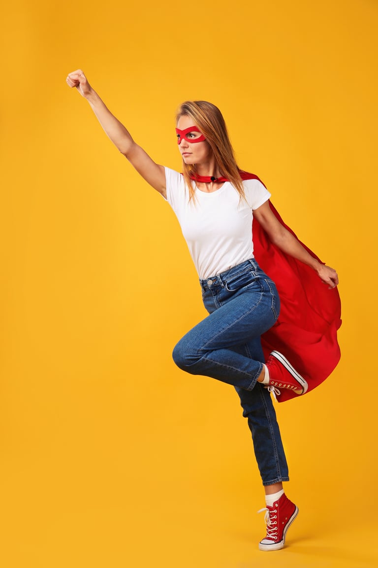 Confident Woman Wearing Superhero Cape and Mask on Yellow Backgr